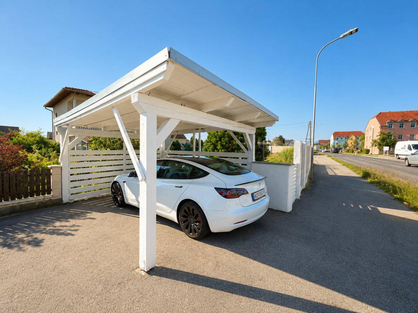 Überdachter Stellplatz für ein Fahrzeug vor dem Haus, direkt an der Straße gelegen.