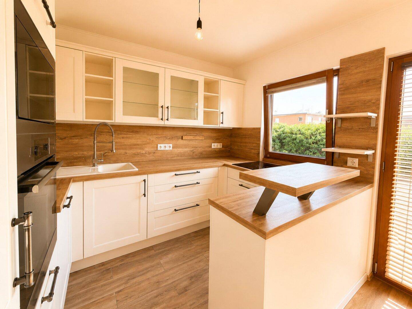 Moderne Einbauküche mit weißen Schränken, Holztheke und integrierten Geräten.