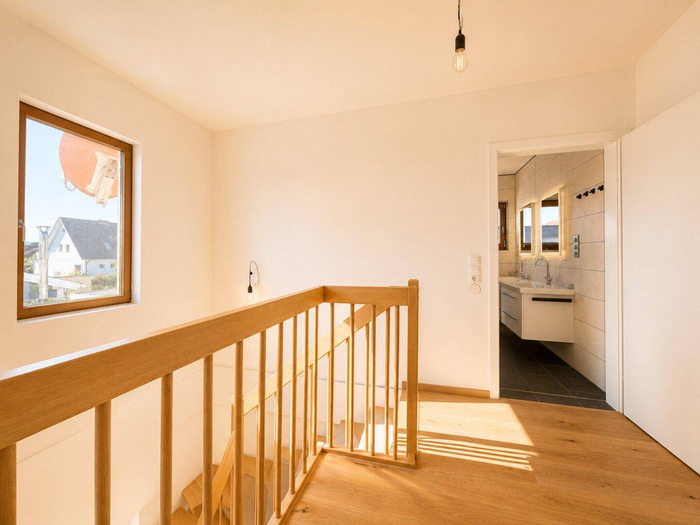 Obergeschoss-Flur mit Blick auf das moderne Badezimmer und natürlichem Lichteinfall.