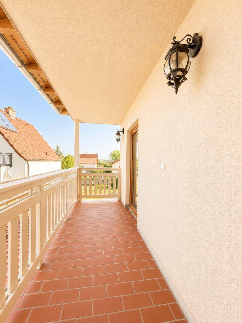 Heller Balkon mit Terrakottafliesen und schmiedeeisernen Laternen, bietet einen weiten Blick auf die Umgebung.
