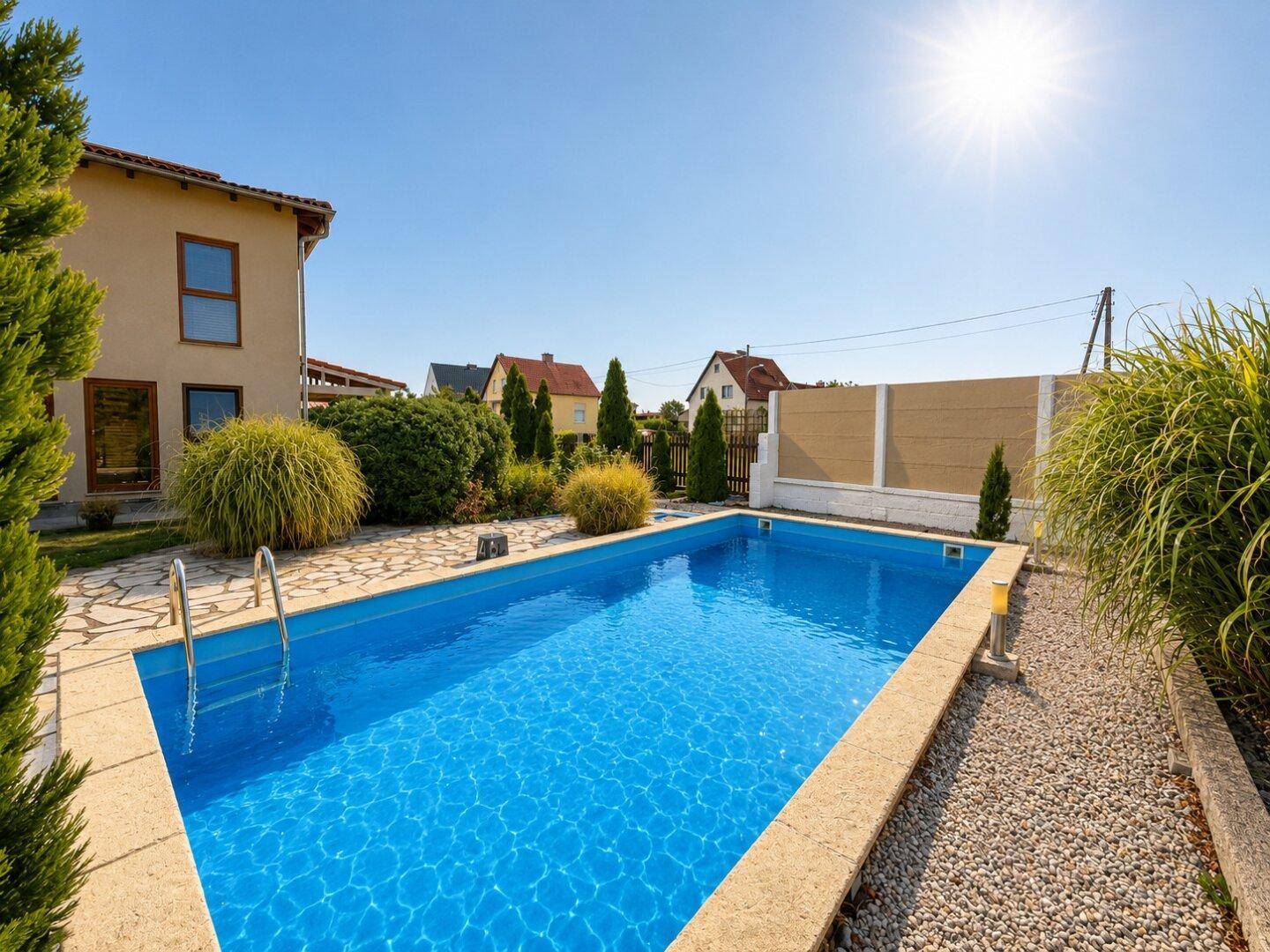Sonniger Garten mit Swimmingpool und gepflegter Bepflanzung, ideal für Entspannung im Freien.