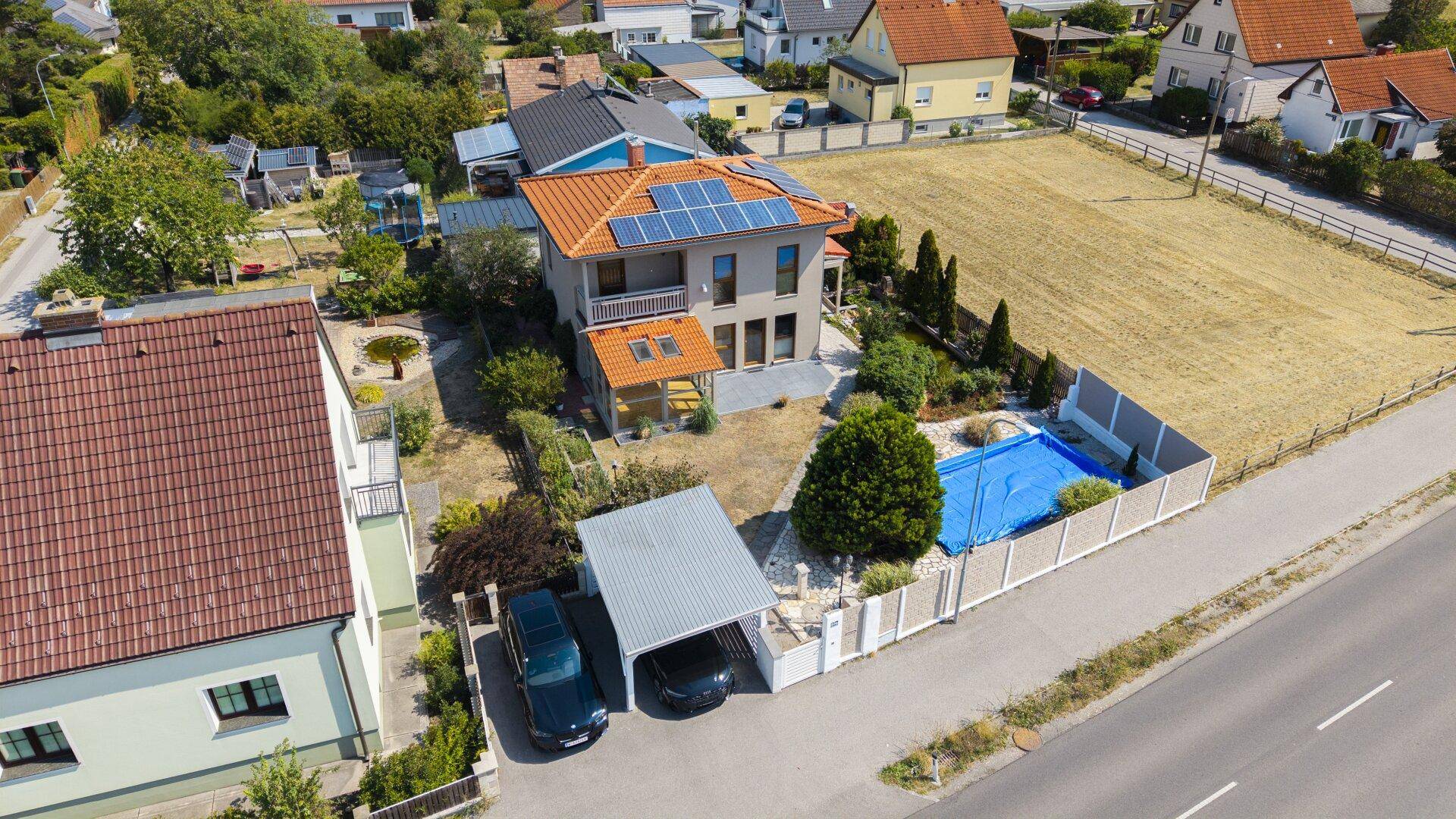 Luftaufnahme des Hauses mit Carport, Pool und weitem Blick auf die ländliche Umgebung.