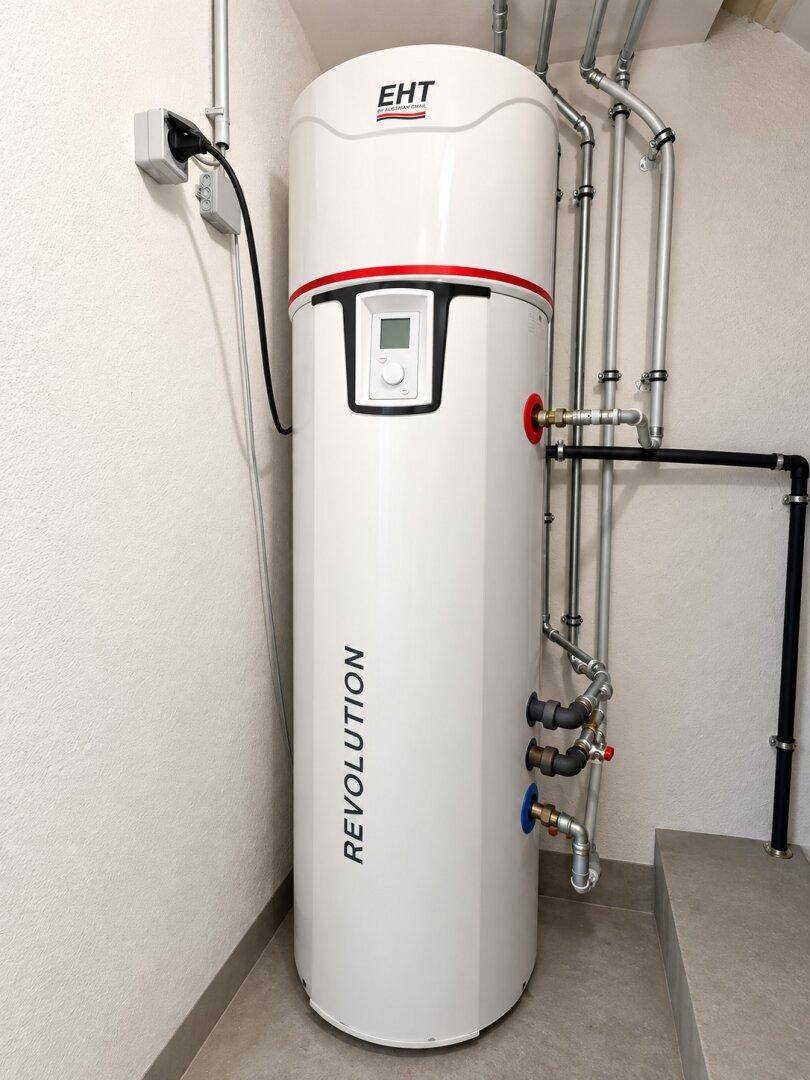 Technikraum mit modernem Warmwasserspeicher und sichtbaren Installationen, in sauberem Zustand.