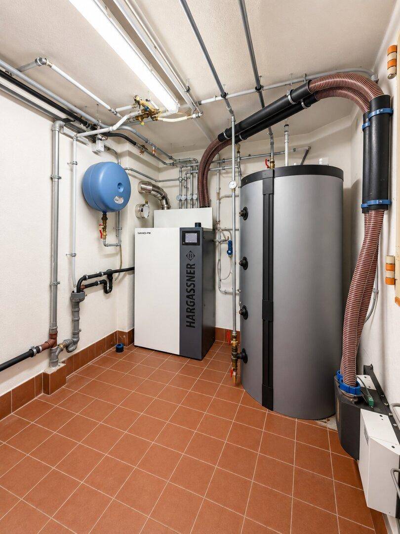 Moderner Heizraum mit effizienter Heizungsanlage und Warmwasserspeicher im Kellergeschoss.