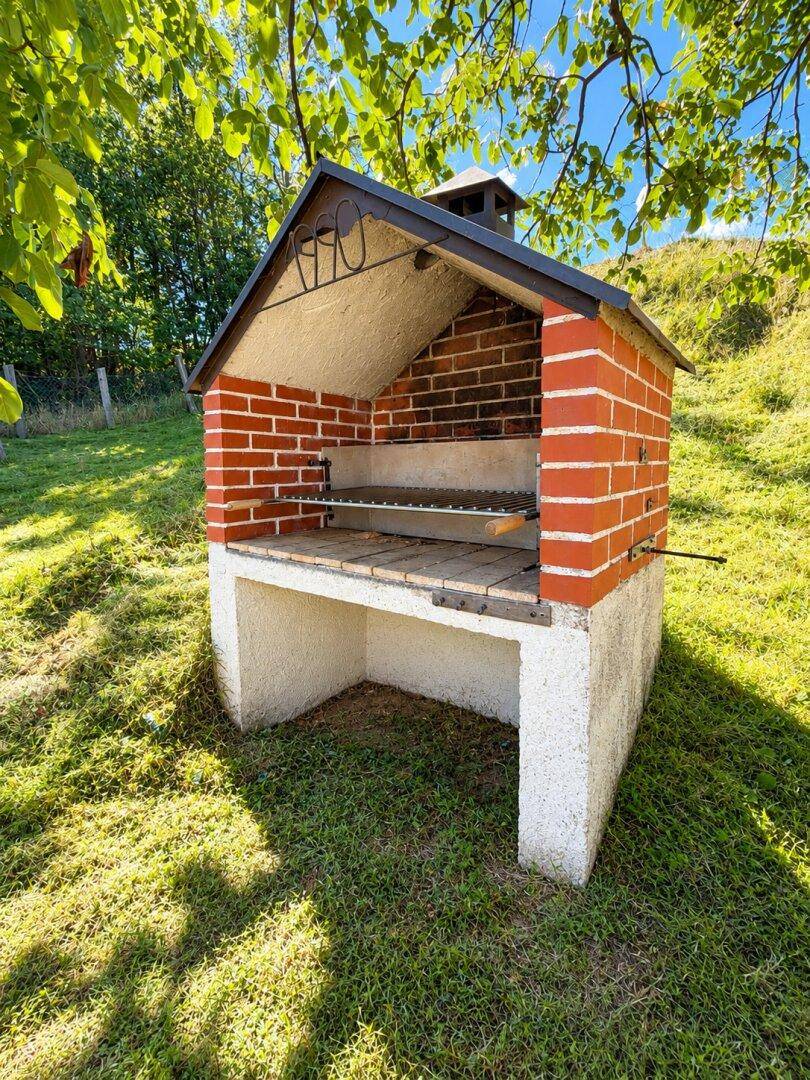 Gemauerter Grillplatz im Garten, ideal für sommerliche Abende und gesellige Runden im Freien.