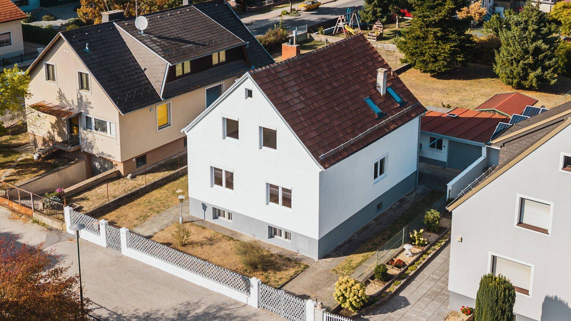 Übersicht des Einfamilienhauses von oben, zeigt das Dach und die angrenzenden Grundstücke mit Gärten.