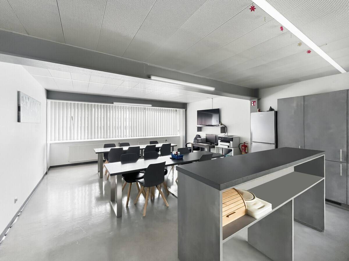 Großer Pausenraum mit Esstischen, Stühlen, Kühlschrank und Küchenzeile, ideal für Mitarbeiter.