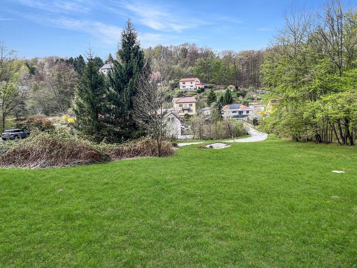 Weitläufige Rasenfläche mit Blick auf die umliegende Hügellandschaft und Häuser.