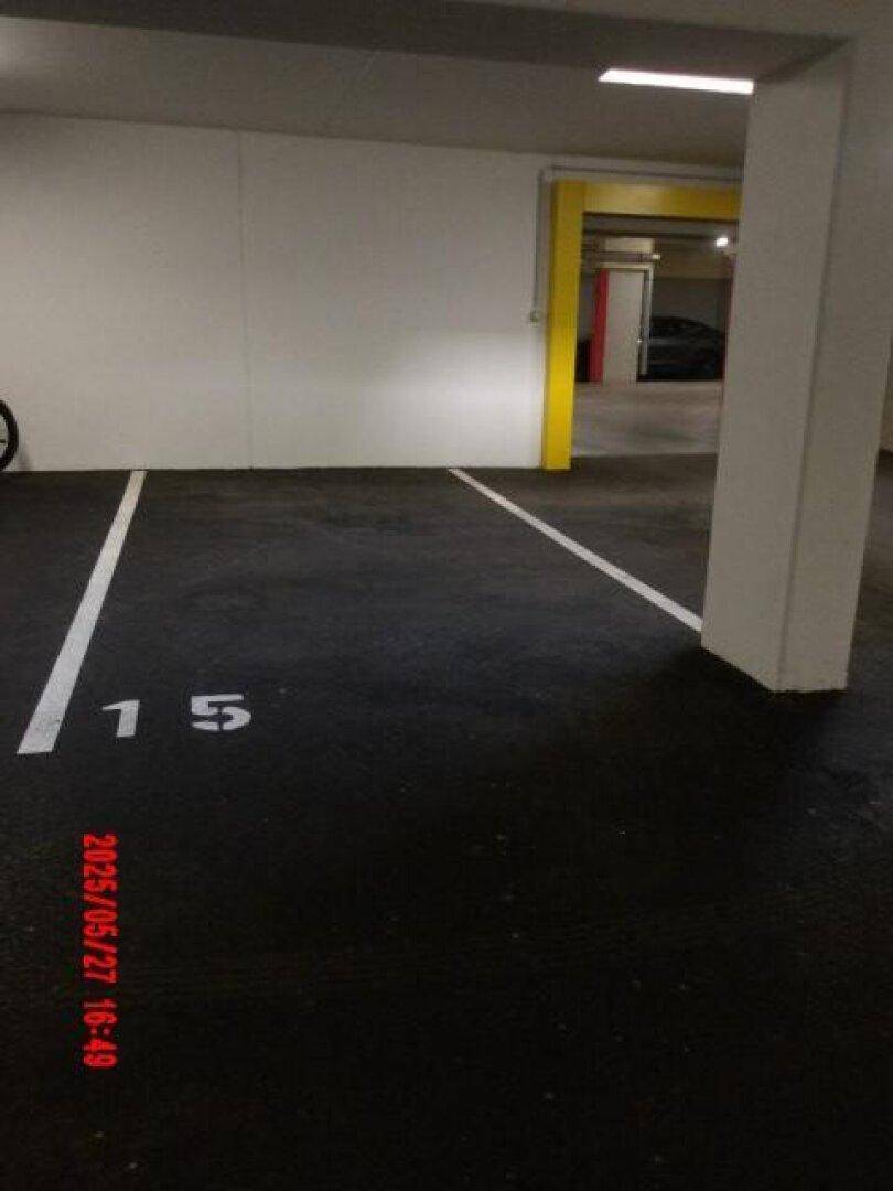 Tiefgaragenstellplatz Nummer 15 in einer gut beleuchteten Tiefgarage mit klaren Markierungen.