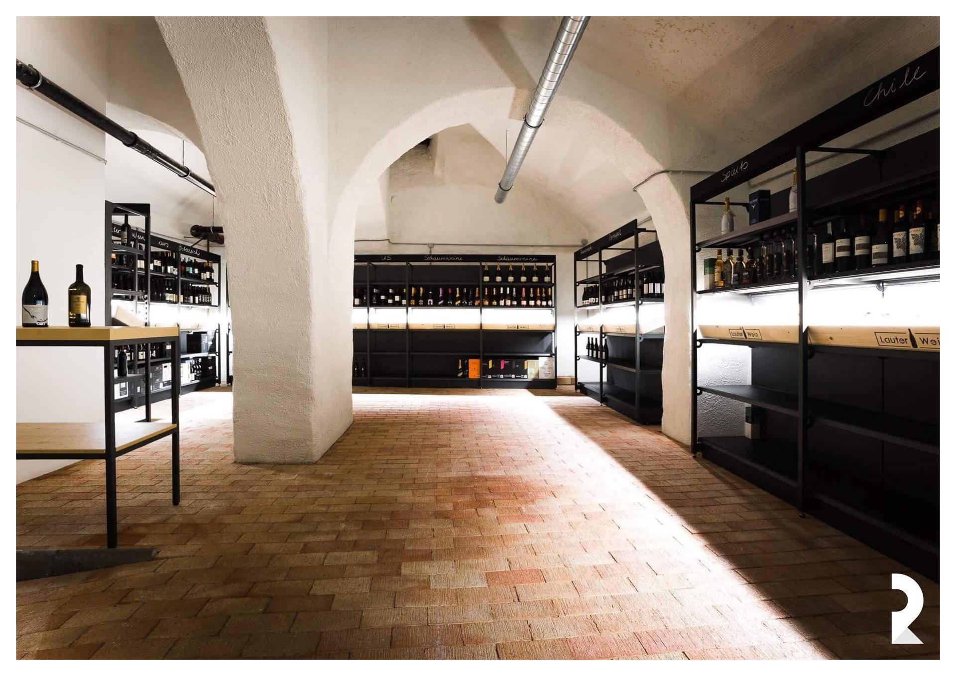 Historischer Kellerraum mit gewölbten Decken, Ziegelboden und Weinregalen, ideal für Lagerung.