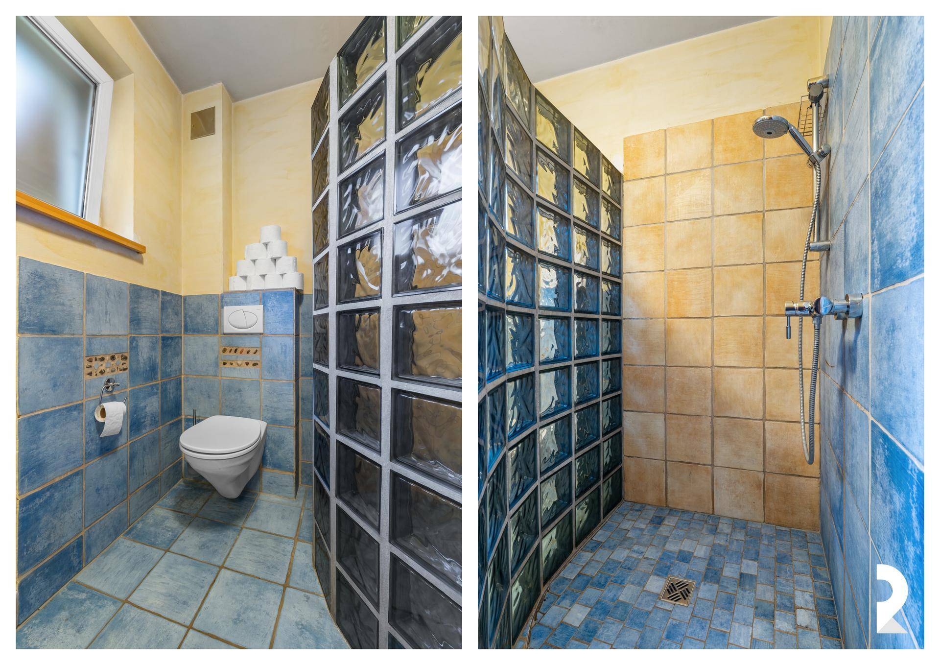Badezimmer mit blauen Fliesen, WC und Duschbereich mit Glasbausteinwand.