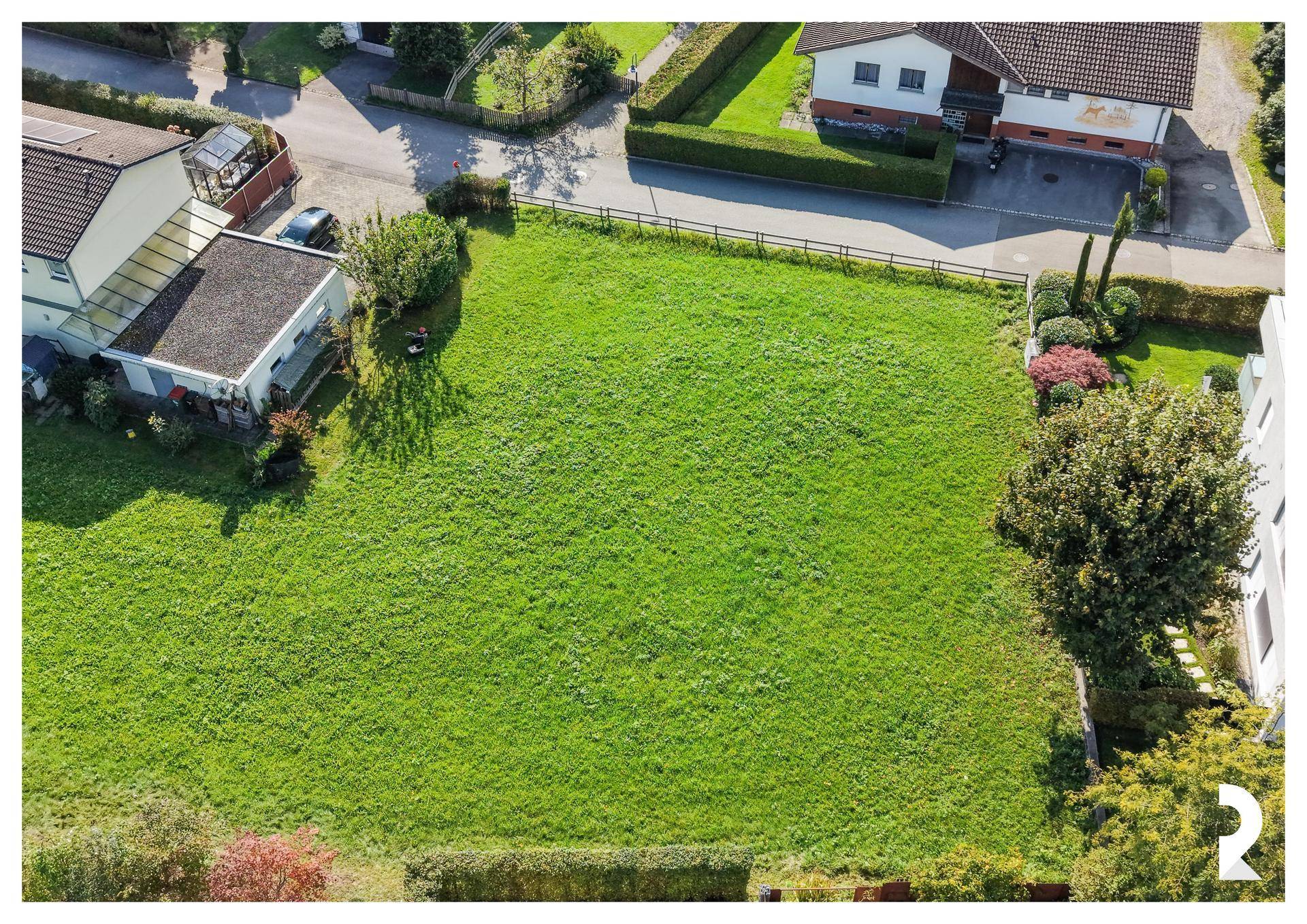 Luftaufnahme der grünen Wiese, die das Baugrundstück in ländlicher Umgebung darstellt.