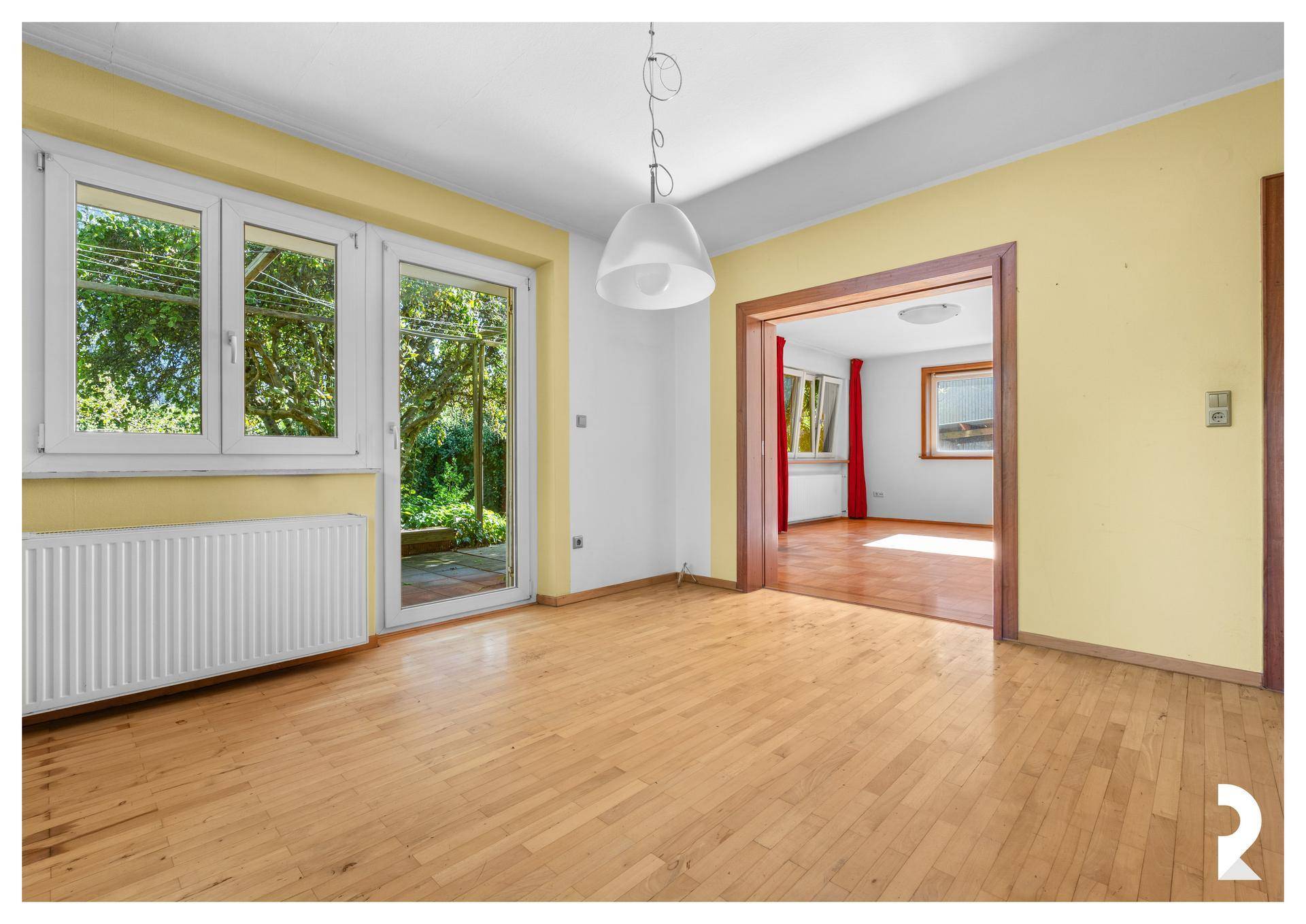 Küche mit gelben Wänden und Holzboden, offener Zugang zum Wohnzimmer.