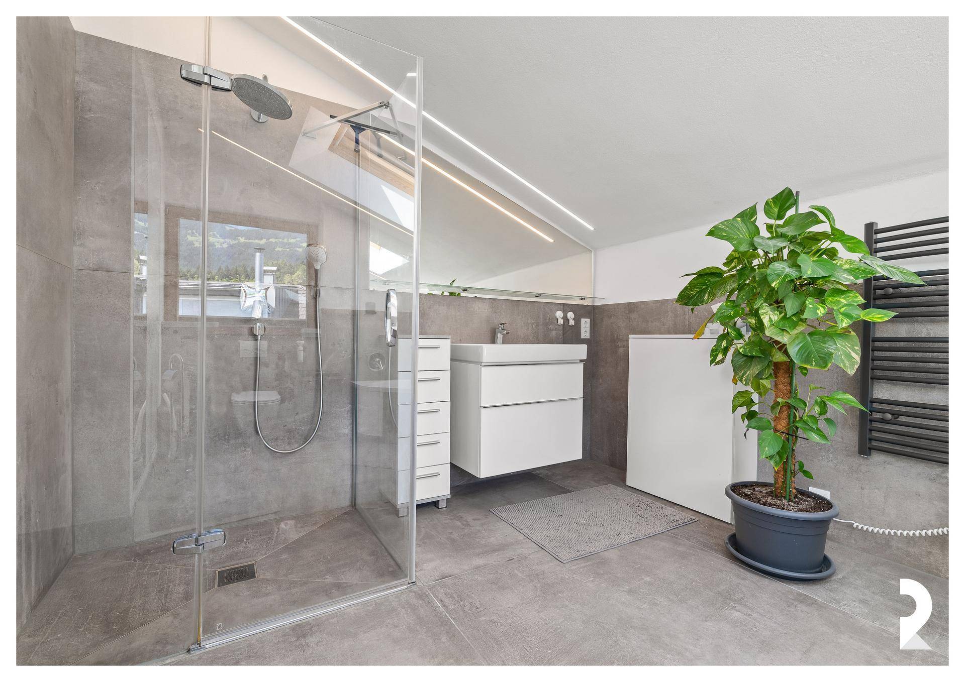 Modernes Badezimmer mit großer begehbarer Dusche, Einzelwaschbecken und Dachfenster.