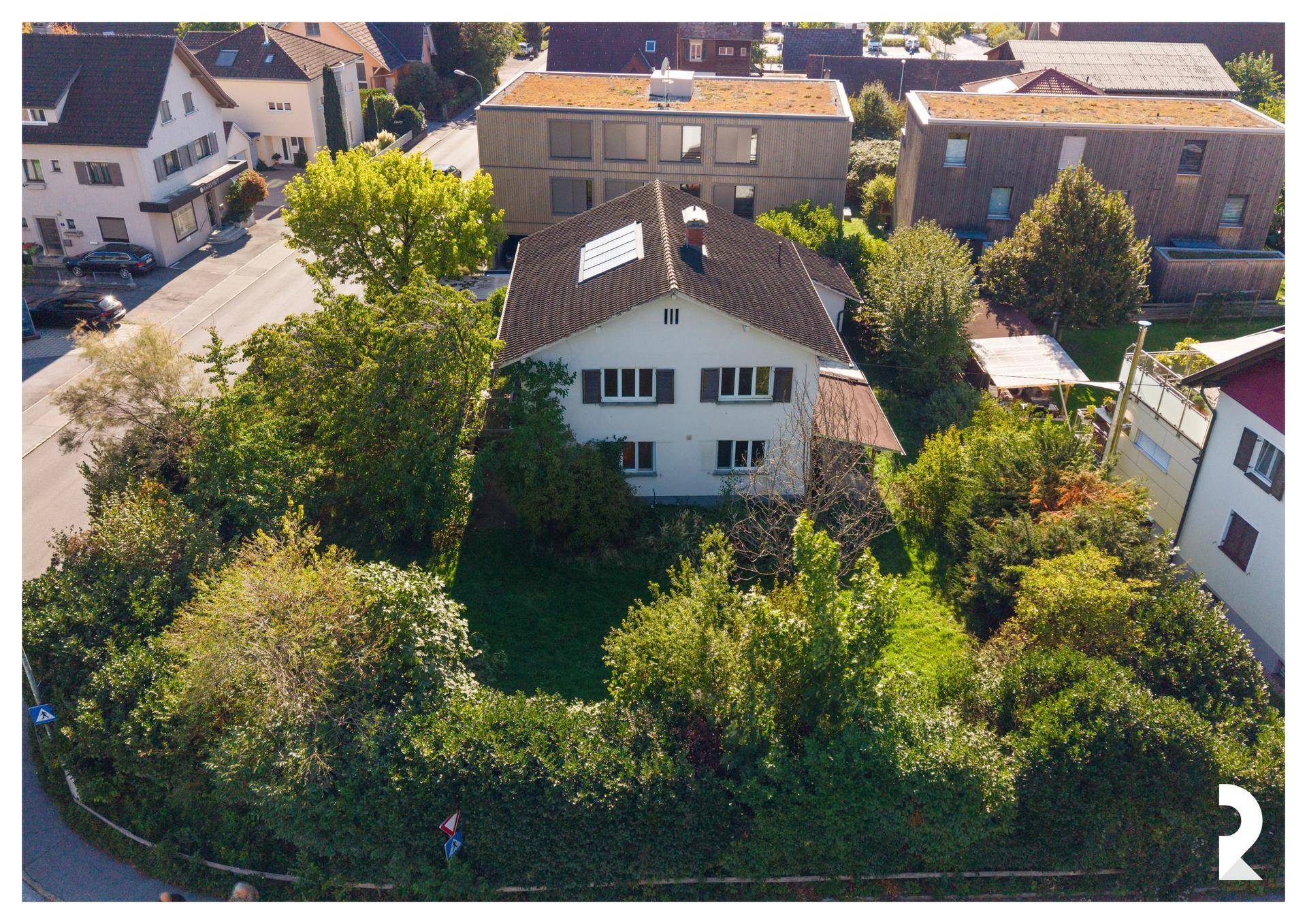 Vogelperspektive des Einfamilienhauses mit großem, gepflegtem Garten und der umliegenden Wohnsiedlung.
