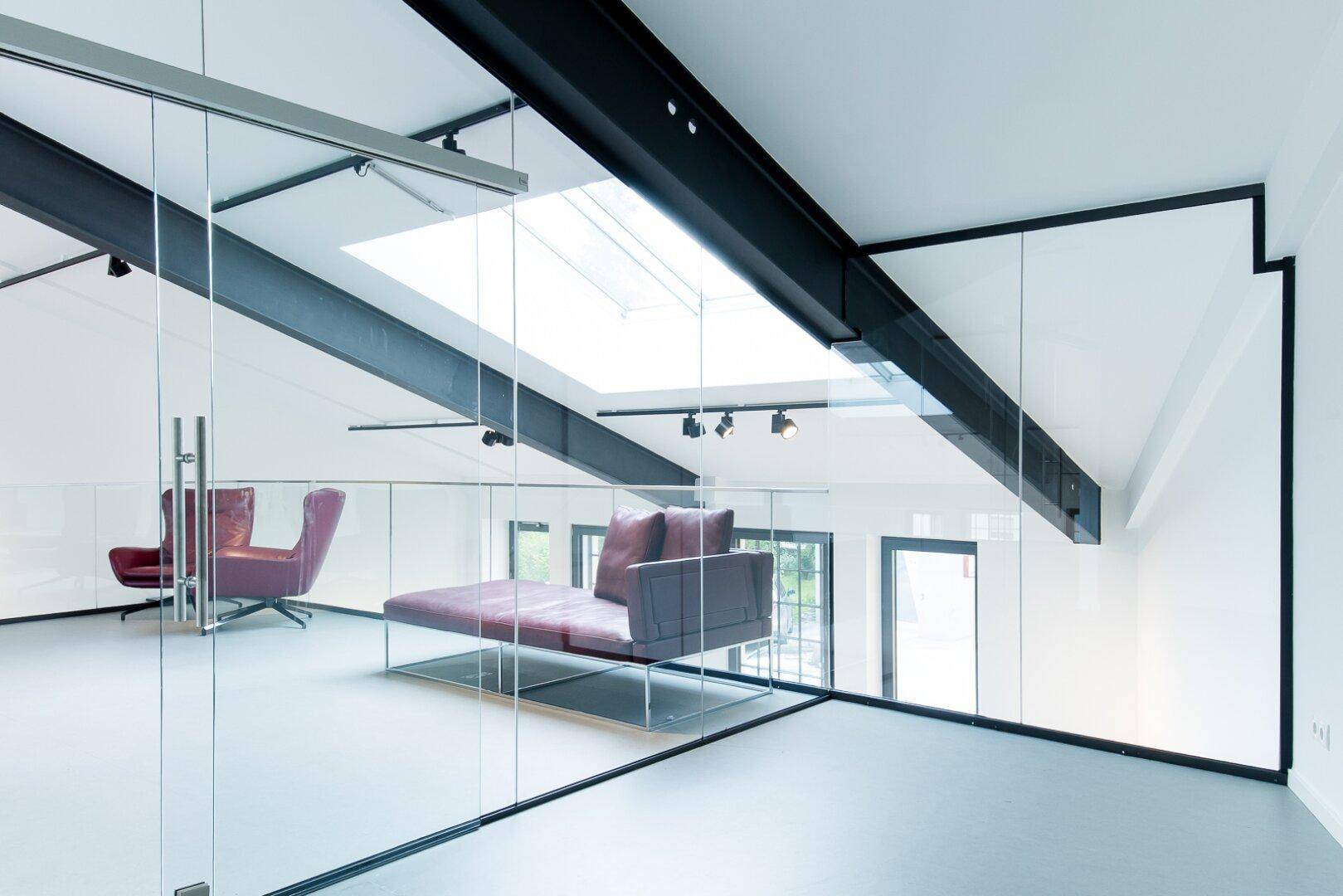 Gemütlicher Lounge-Bereich auf der Galerie mit Dachfenstern und Blick in den offenen Raum.