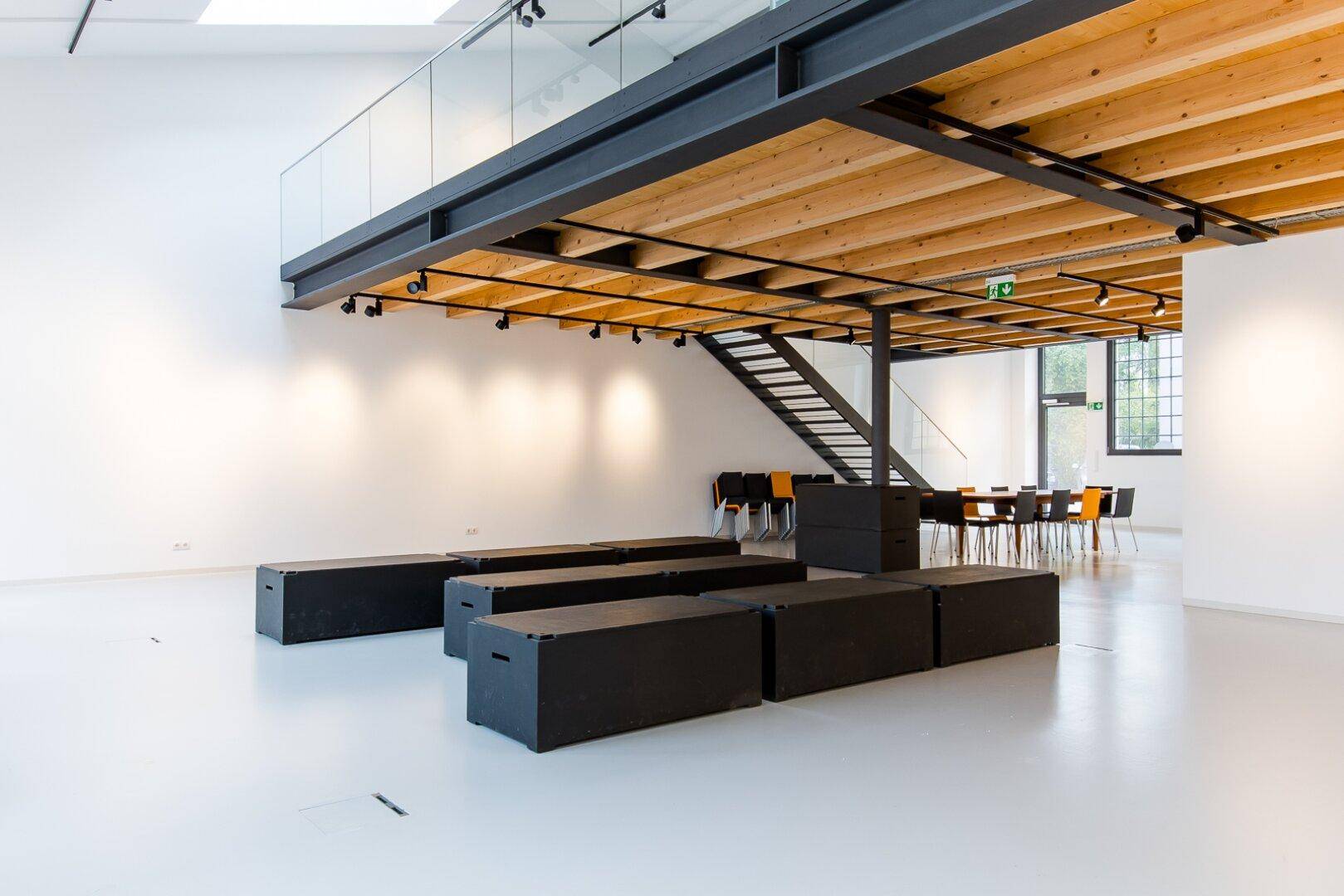 Geräumiger, offener Wohnbereich mit minimalistischer Einrichtung und Blick auf die obere Galerie.