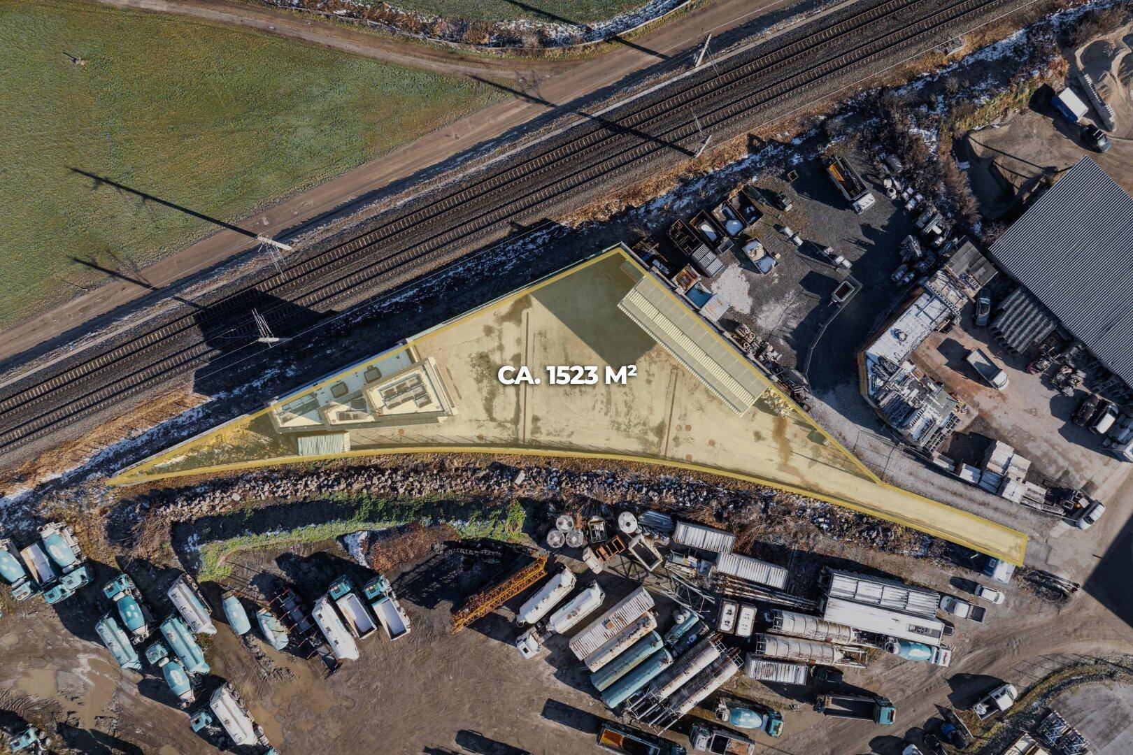Luftaufnahme eines Grundstücks von ca. 1523 m² mit angrenzenden Bahngleisen und Industrieanlagen.