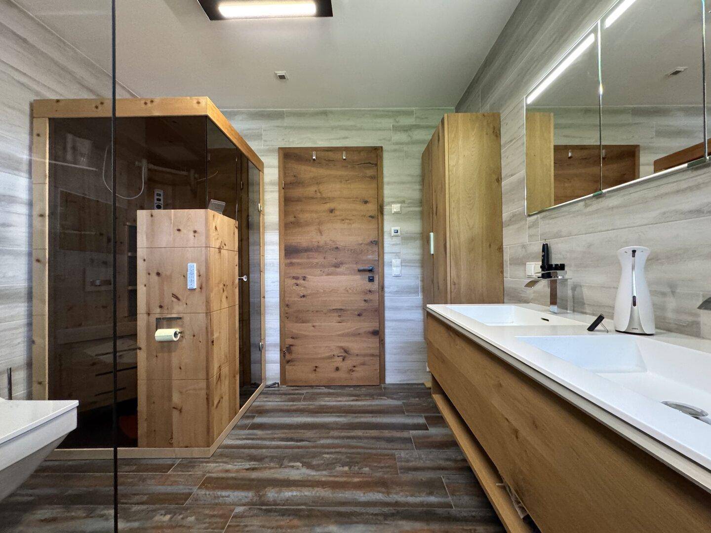 Geräumiges Badezimmer mit integrierter Sauna, Doppelwaschbecken und Holzelementen.