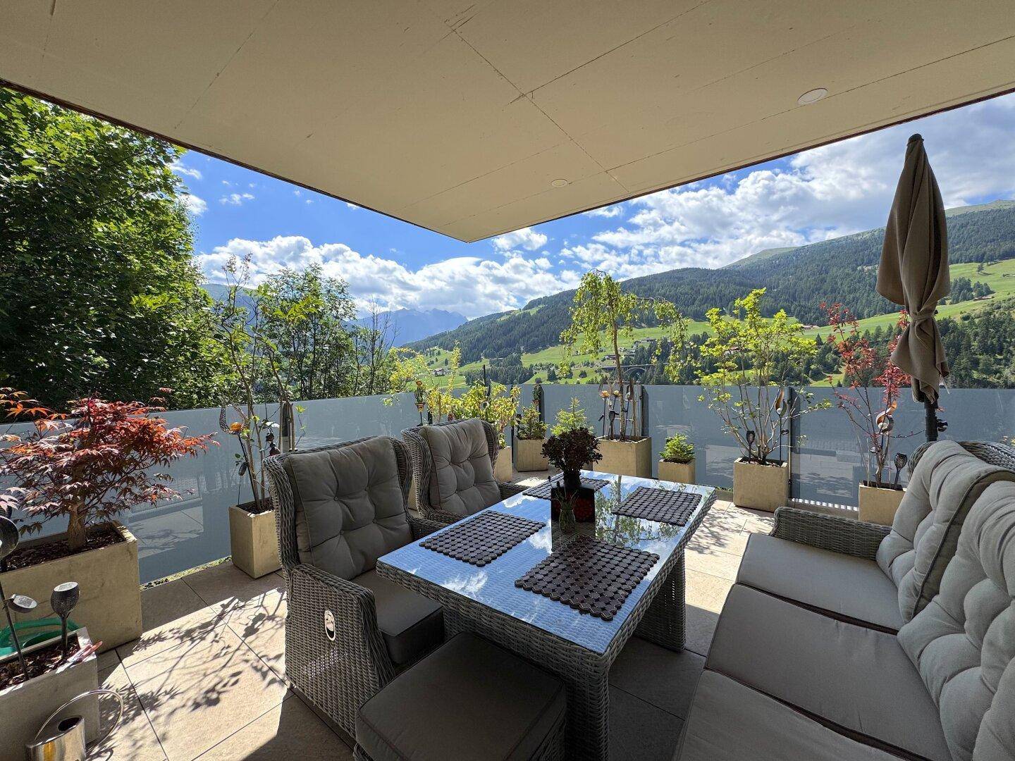 Große, möblierte Terrasse mit Bergblick und Pflanzen in Töpfen für entspannte Stunden.