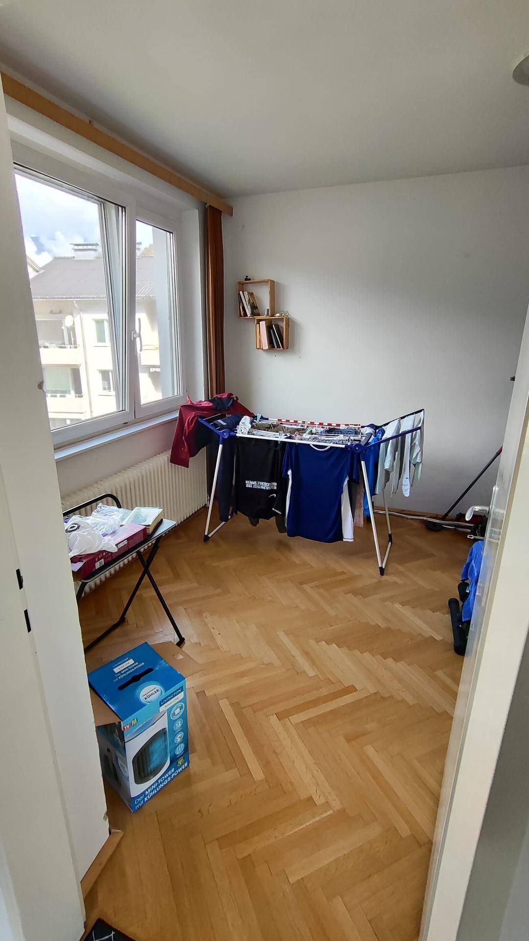 Raum mit Parkettboden und Wäscheständer, ideal als Hauswirtschaftsraum nutzbar.