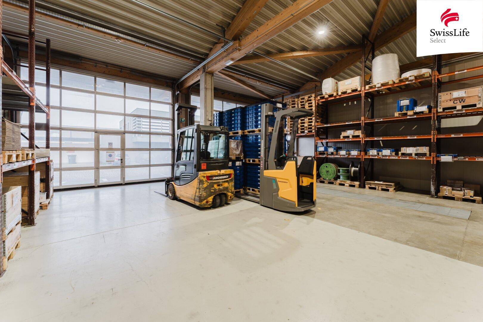Lagerhalle mit Gabelstaplern, hohen Regalen und Rolltoren, optimiert für effiziente Logistikabläufe.