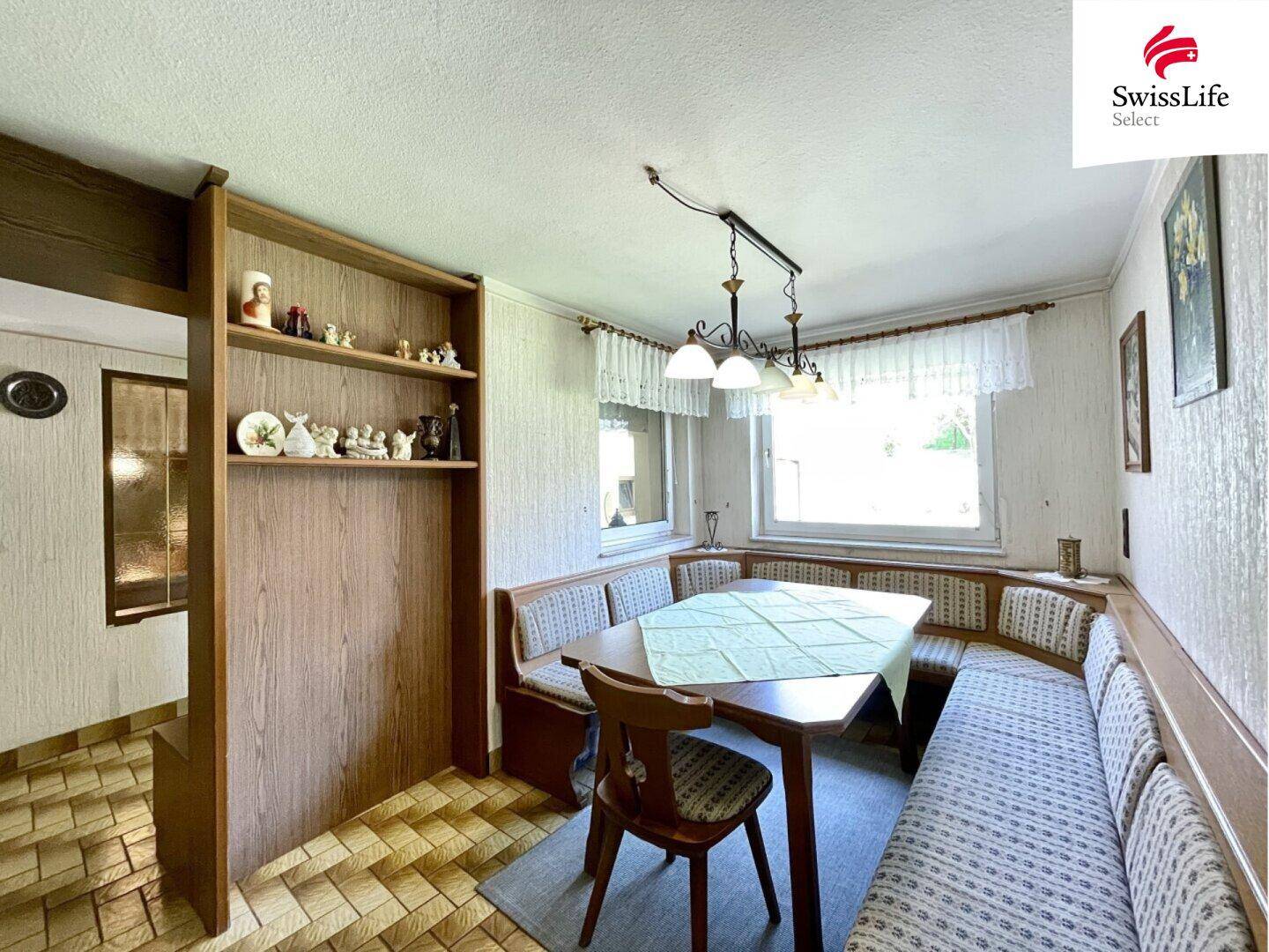 Traditioneller Essbereich mit Eckbank, Holztisch und karierten Fliesen, ideal für Familienmahlzeiten.