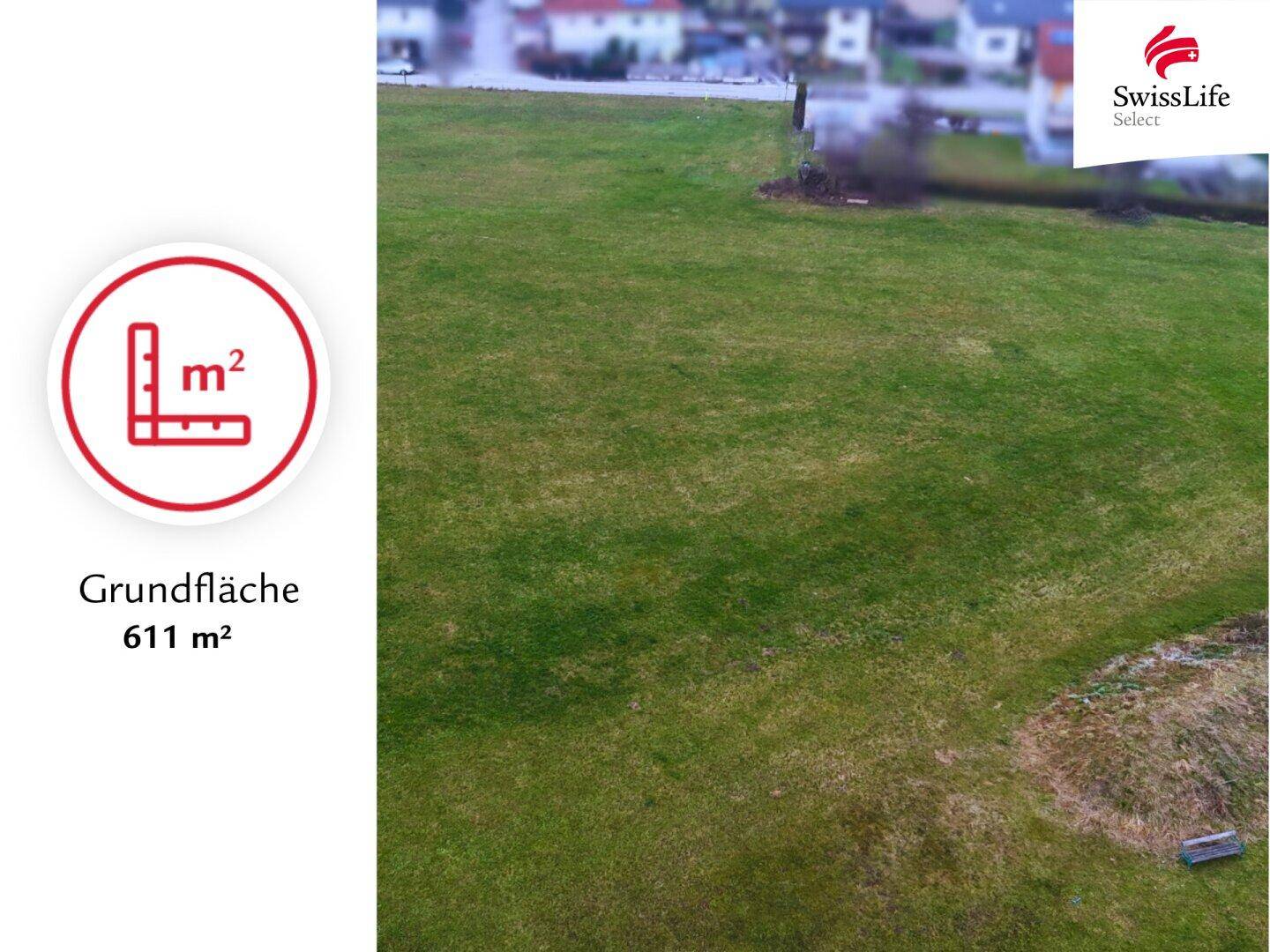 Weitläufige Grünfläche eines Baugrundstücks mit Rasen und Blick auf die umliegende Bebauung.