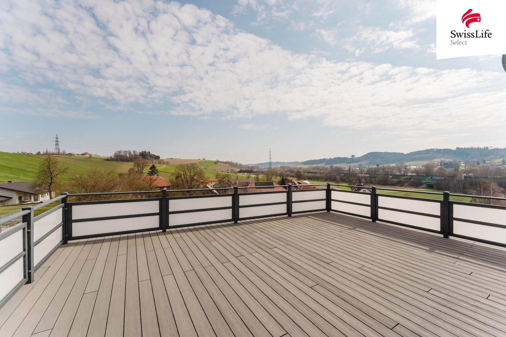 Große Dachterrasse mit Holzboden und weitem Blick über die ländliche Umgebung.