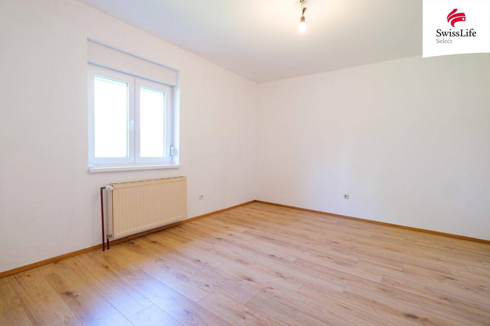 Leerer Raum mit hellen Wänden und Holzboden, der vielfältige Nutzungsmöglichkeiten bietet.
