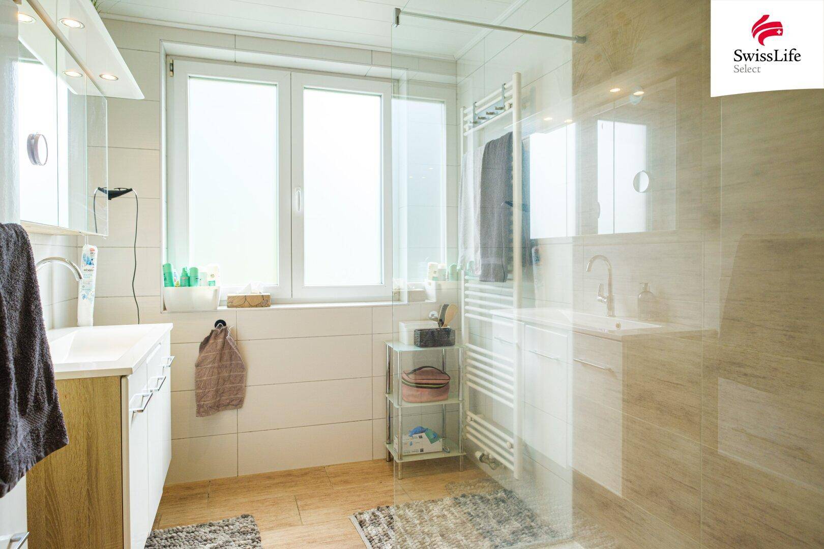 Modernes Badezimmer mit ebenerdiger Dusche, Einzelwaschbecken und Fenster für natürliche Belüftung.