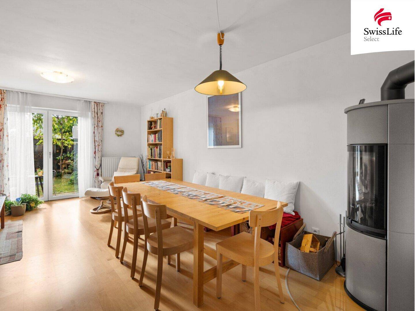 Geräumiger Wohn-Essbereich mit Holzboden, Kaminofen und Blick in den Garten.