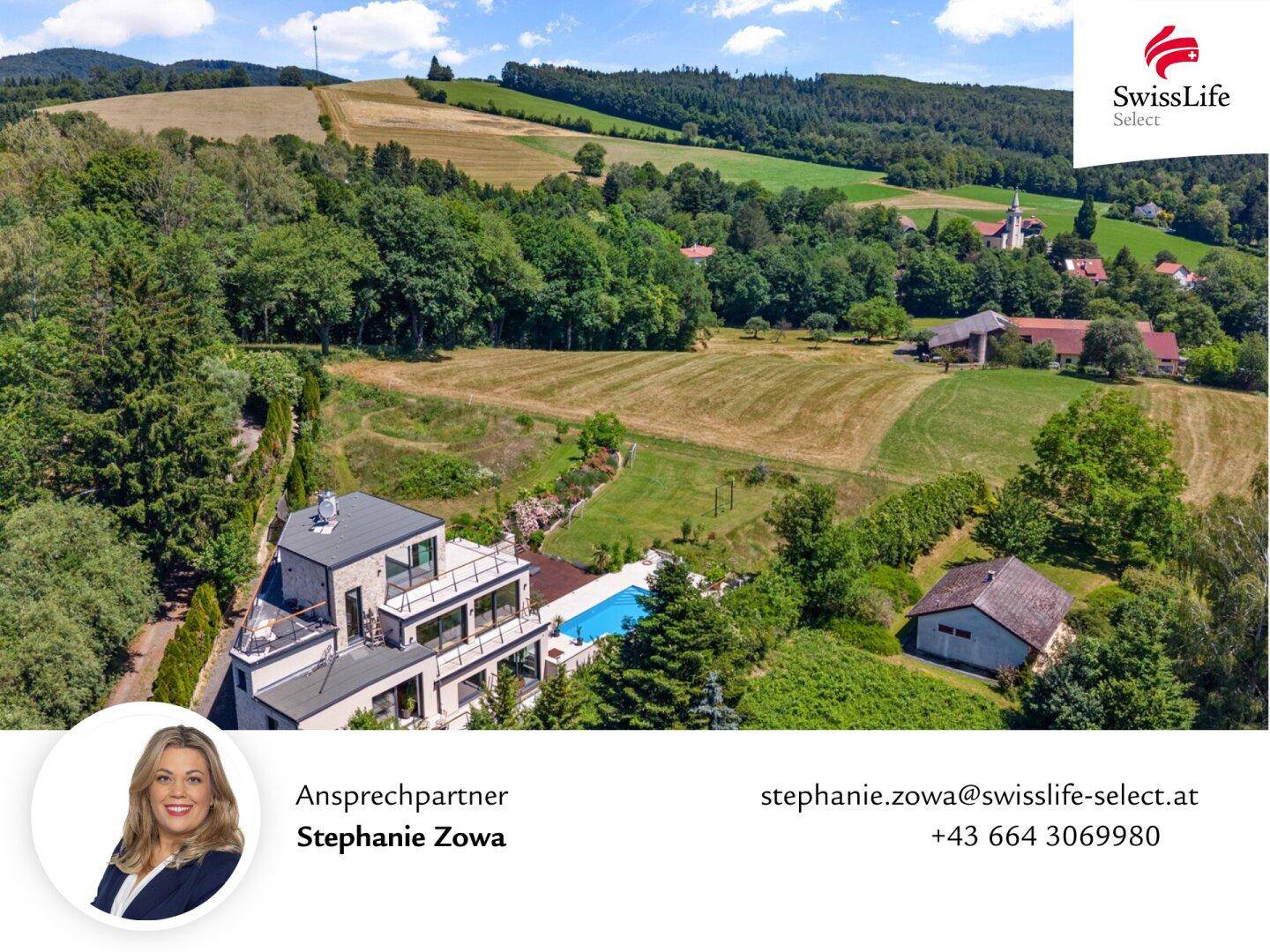 Luftaufnahme der modernen Villa eingebettet in die grüne Hügellandschaft.