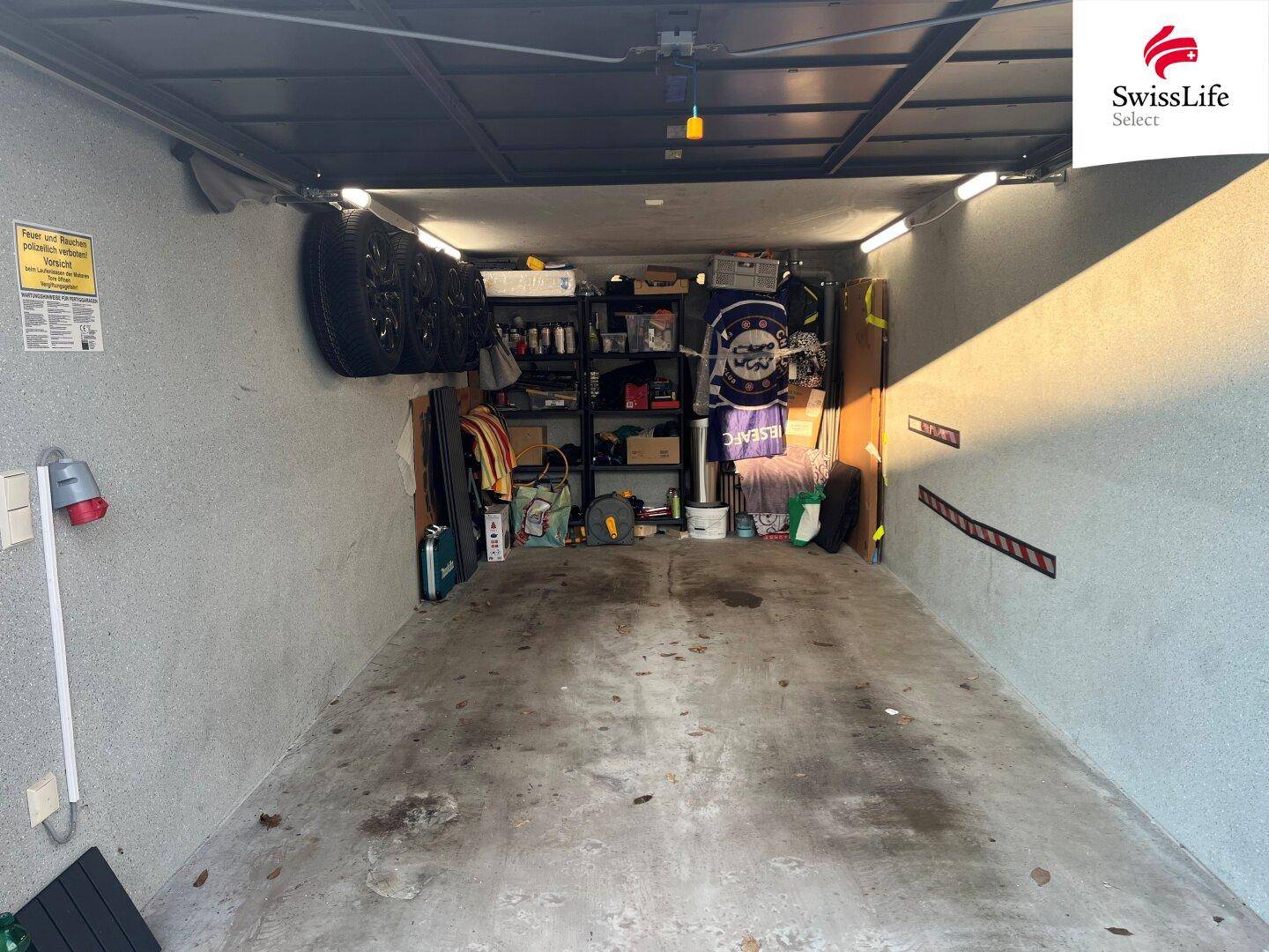 Geräumige Garage mit Stauraum und Beleuchtung, ideal für Fahrzeuge und Lagerung.