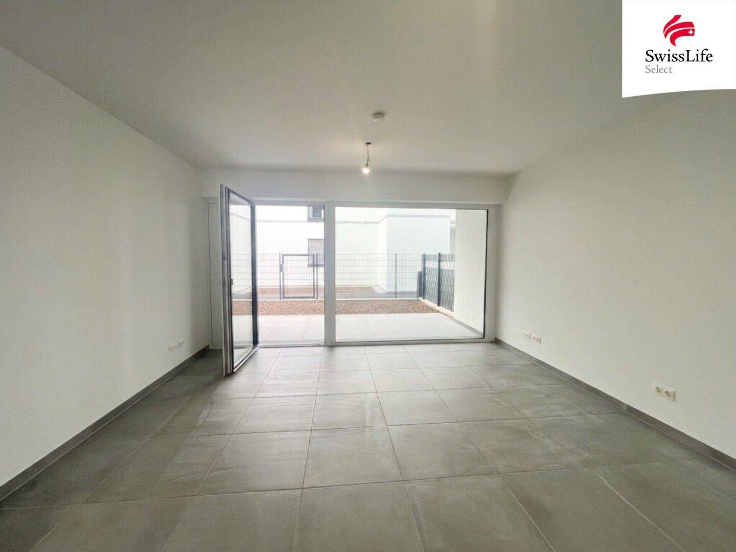 Geräumiges, helles Wohnzimmer mit großen Fenstern und direktem Zugang zum Außenbereich.