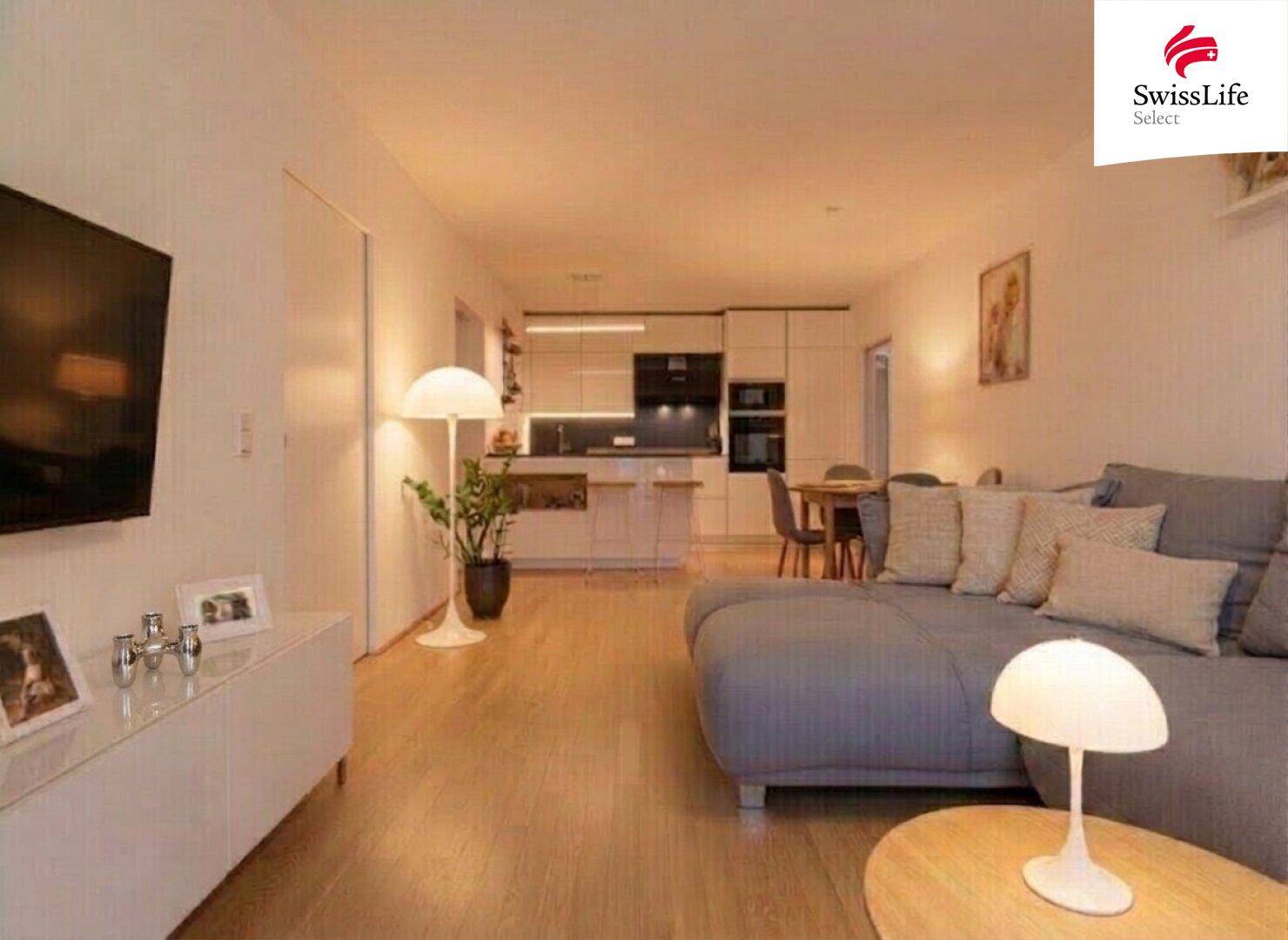Abendliche Atmosphäre im offenen Wohnbereich mit stilvoller Beleuchtung und moderner Küche.