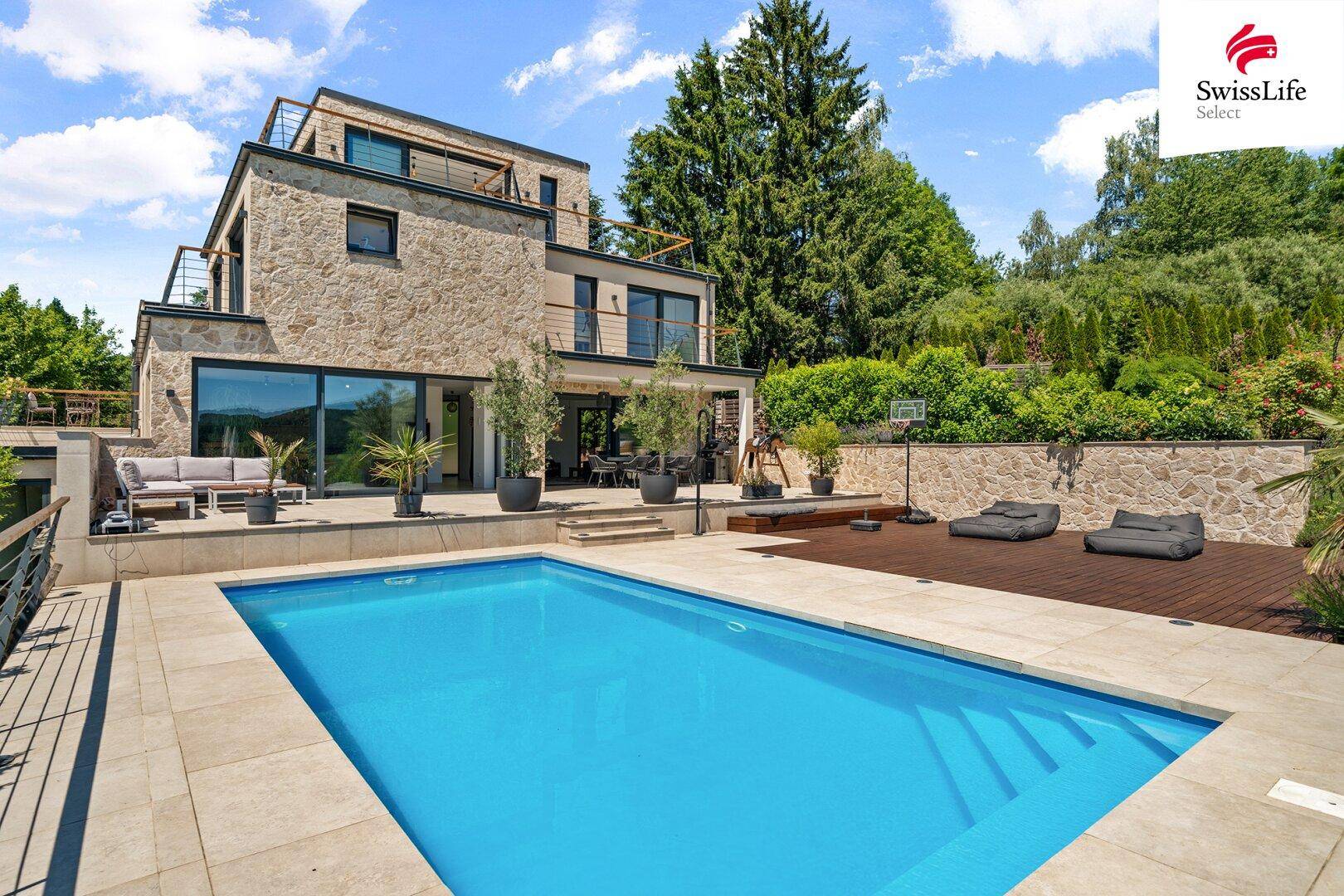 Moderne Architektenvilla mit großem Pool, Sonnenterrasse und üppiger Grünanlage in ruhiger Lage.