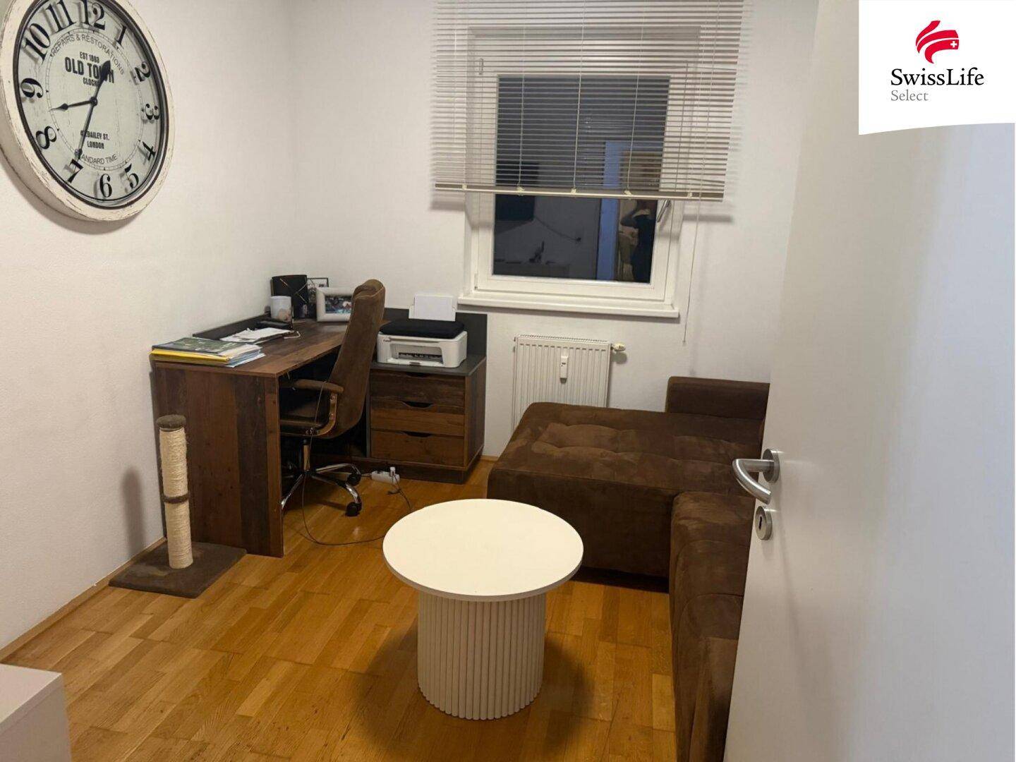 Ruhiges Arbeitszimmer mit Schreibtisch, Bürostuhl und einem bequemen Sofa, ideal für Home-Office.