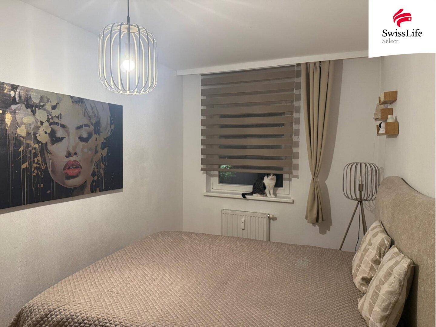 Modern eingerichtetes Schlafzimmer mit großem Bett, Kunstwerk und Fenster mit Jalousien für Privatsphäre.