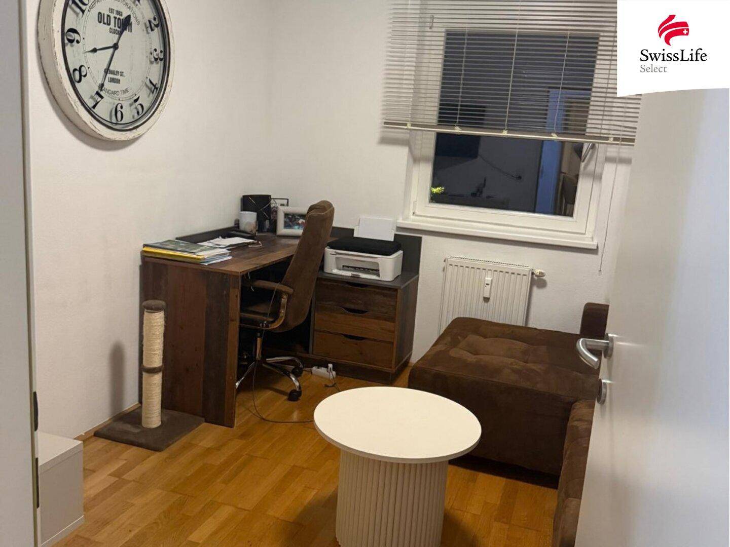 Ruhiges Arbeitszimmer mit Schreibtisch, Bürostuhl und einem bequemen Sofa, ideal für Home-Office.