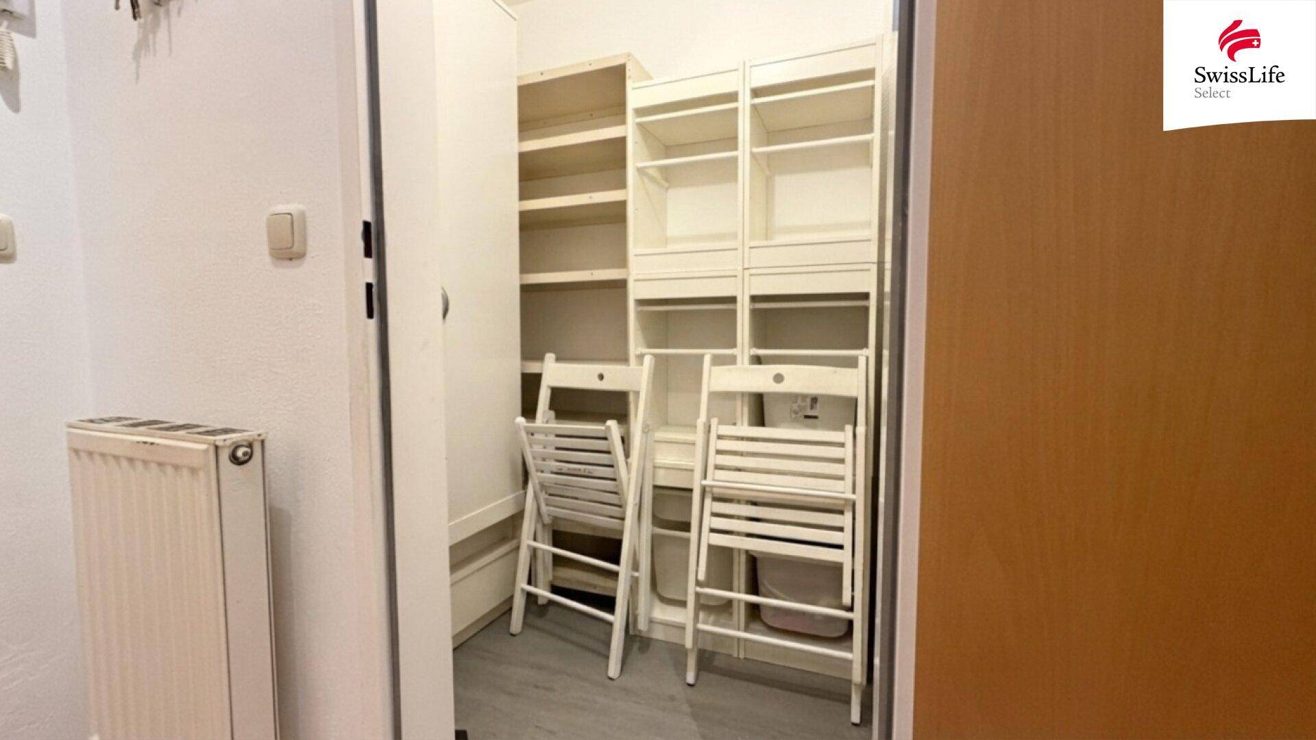 Praktischer Abstellraum mit Regalen und Klappstühlen für zusätzlichen Stauraum.