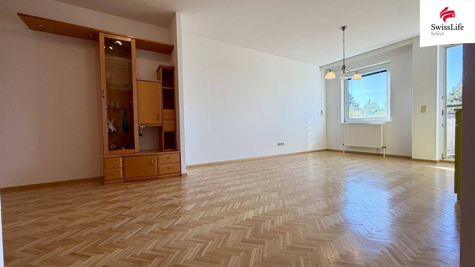 Großer offener Wohn-Essbereich mit Fischgrätparkett und viel Tageslicht.