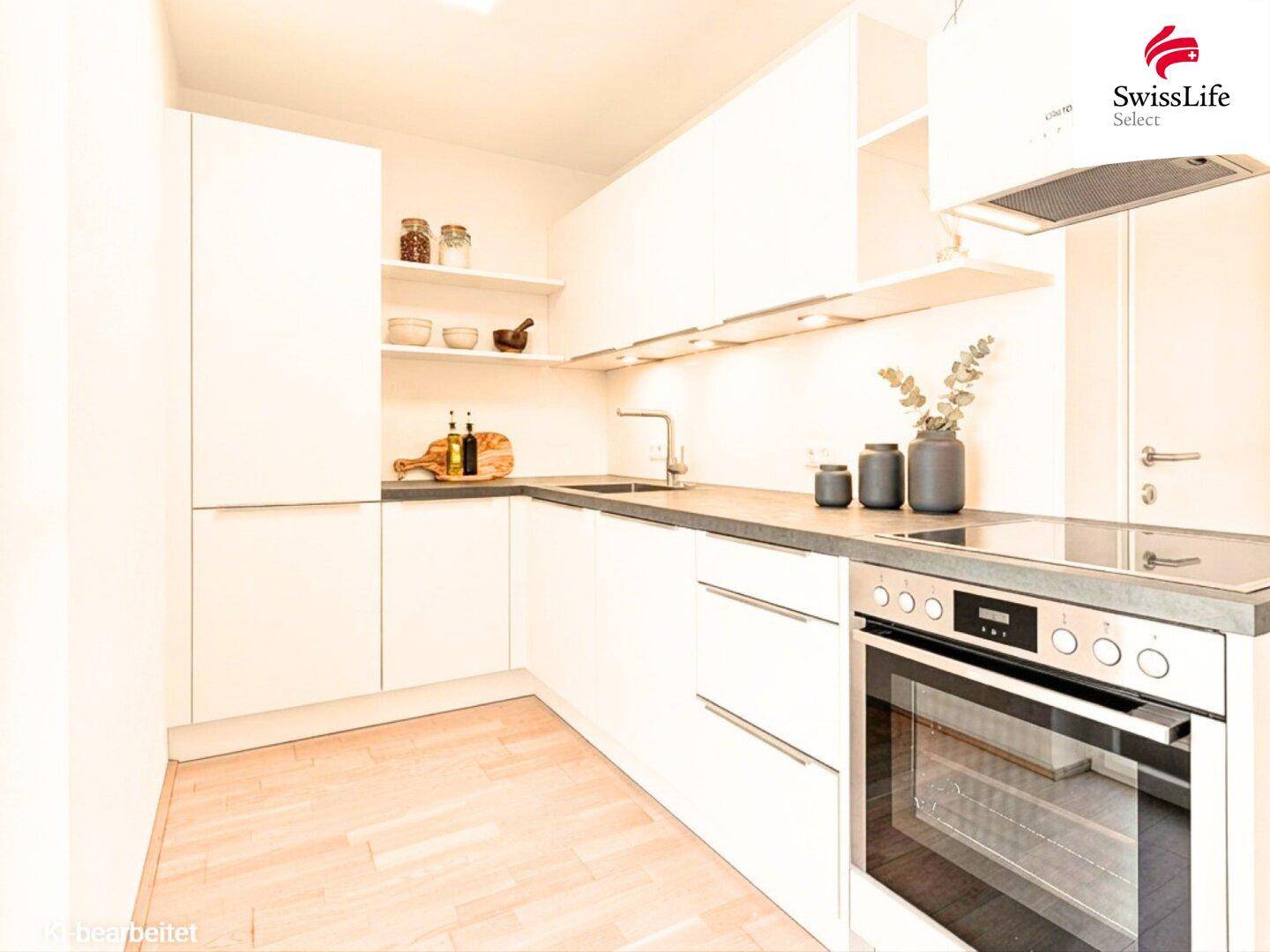 Moderne Einbauküche mit weißen Schränken, integrierten Geräten und hellem Holzfußboden.