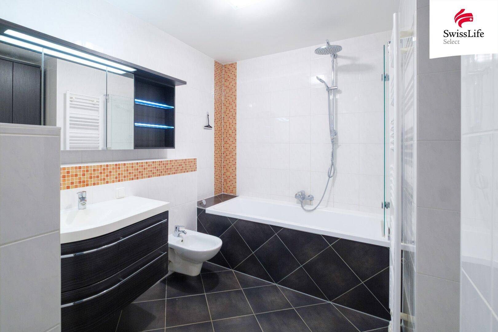 Modernes Badezimmer mit Badewanne, Dusche, Bidet und stilvollen Fliesen in Weiß und Dunkelgrau.