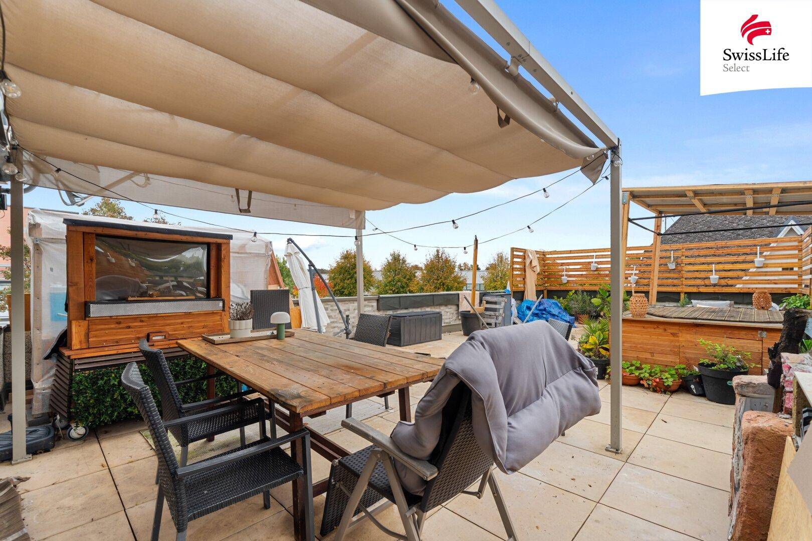 Gemütliche Dachterrasse mit Esstisch, Sitzgelegenheiten und Sonnenschutz für entspannte Stunden.