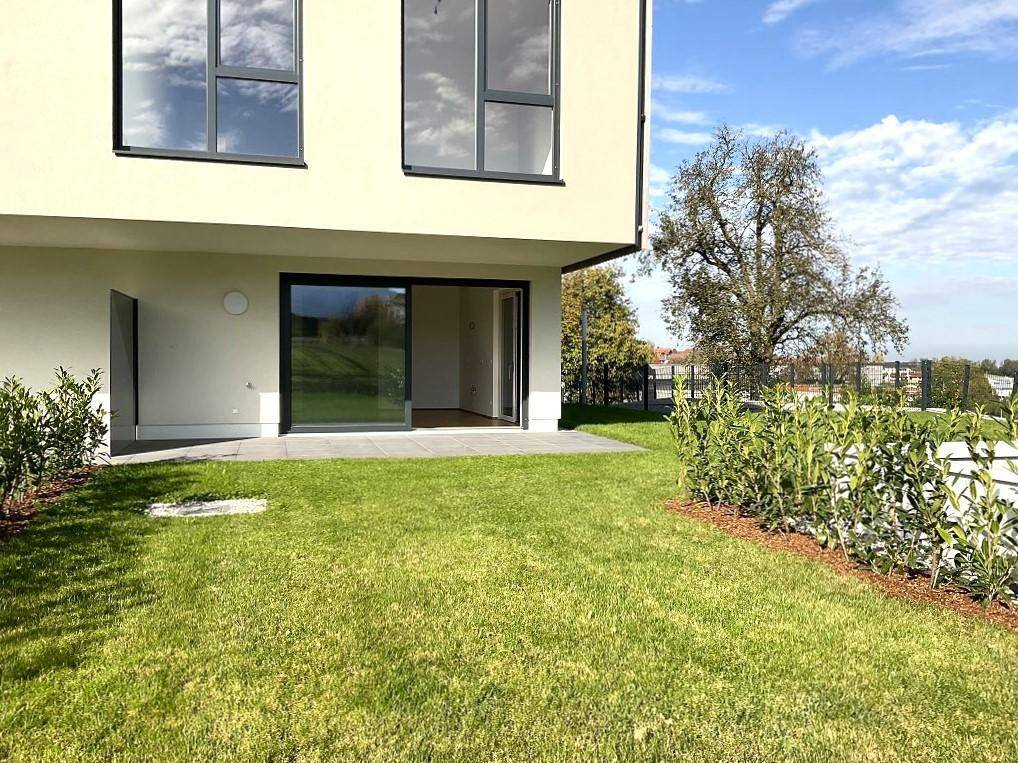 Gepflegter Rasenbereich mit Zugang zur Terrasse und Blick auf die umliegende Natur.