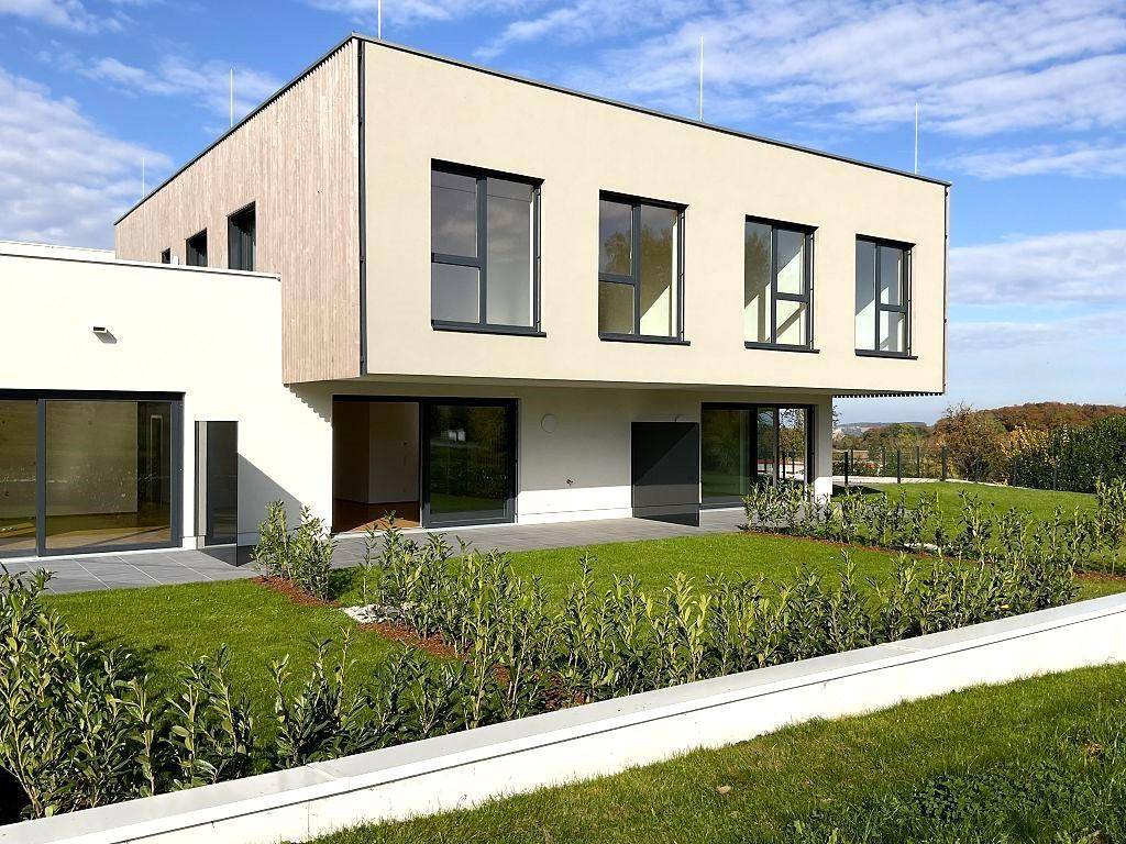 Modernes Gebäude mit großem Garten und weitem Blick in die Landschaft.