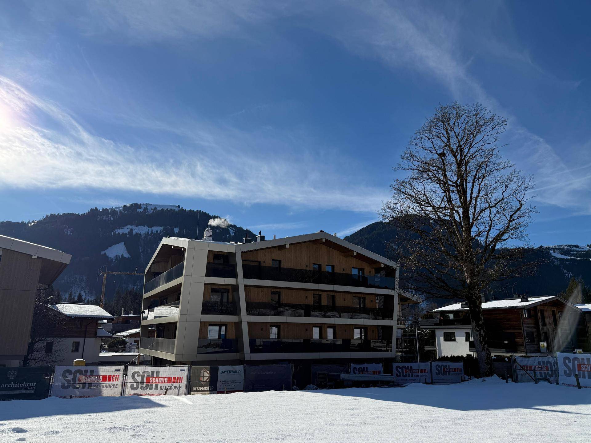 Neubau-Wohnhaus in alpiner Umgebung mit verschneiter Landschaft und klarem Winterhimmel.