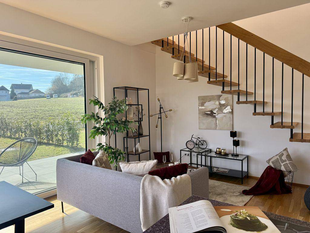 Moderner Wohnbereich mit bequemer Couch, stilvoller Dekoration und Zugang zur Terrasse.