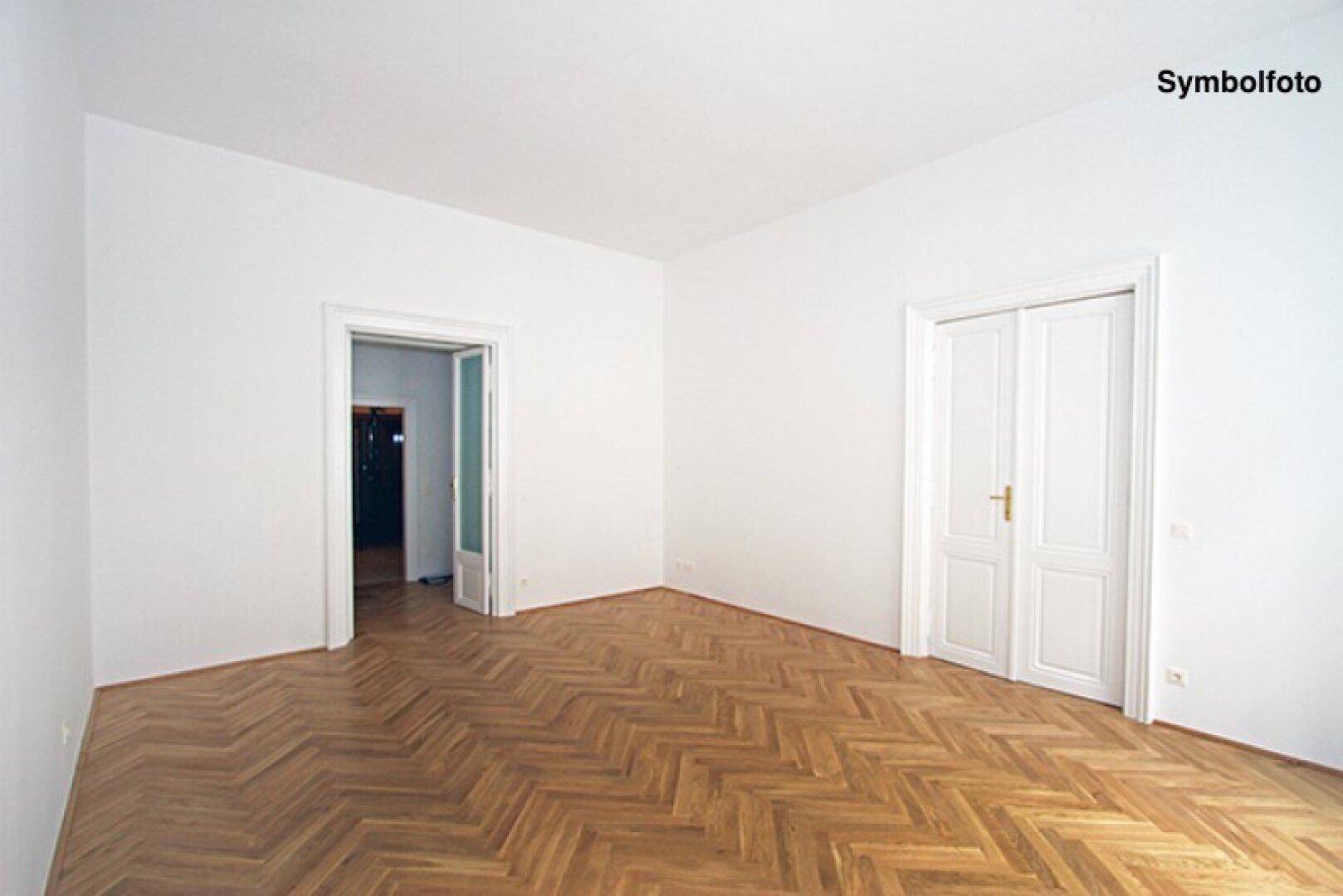Klassischer Raum mit Fischgrätparkett, hohen Decken und traditionellen Doppeltüren.